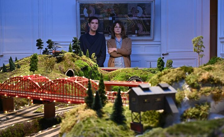 Szene aus dem Film "EIN GLÜCKSFALL" Ein Mann und eine Frau stehen im Hintergund einer Modelbahnanlage