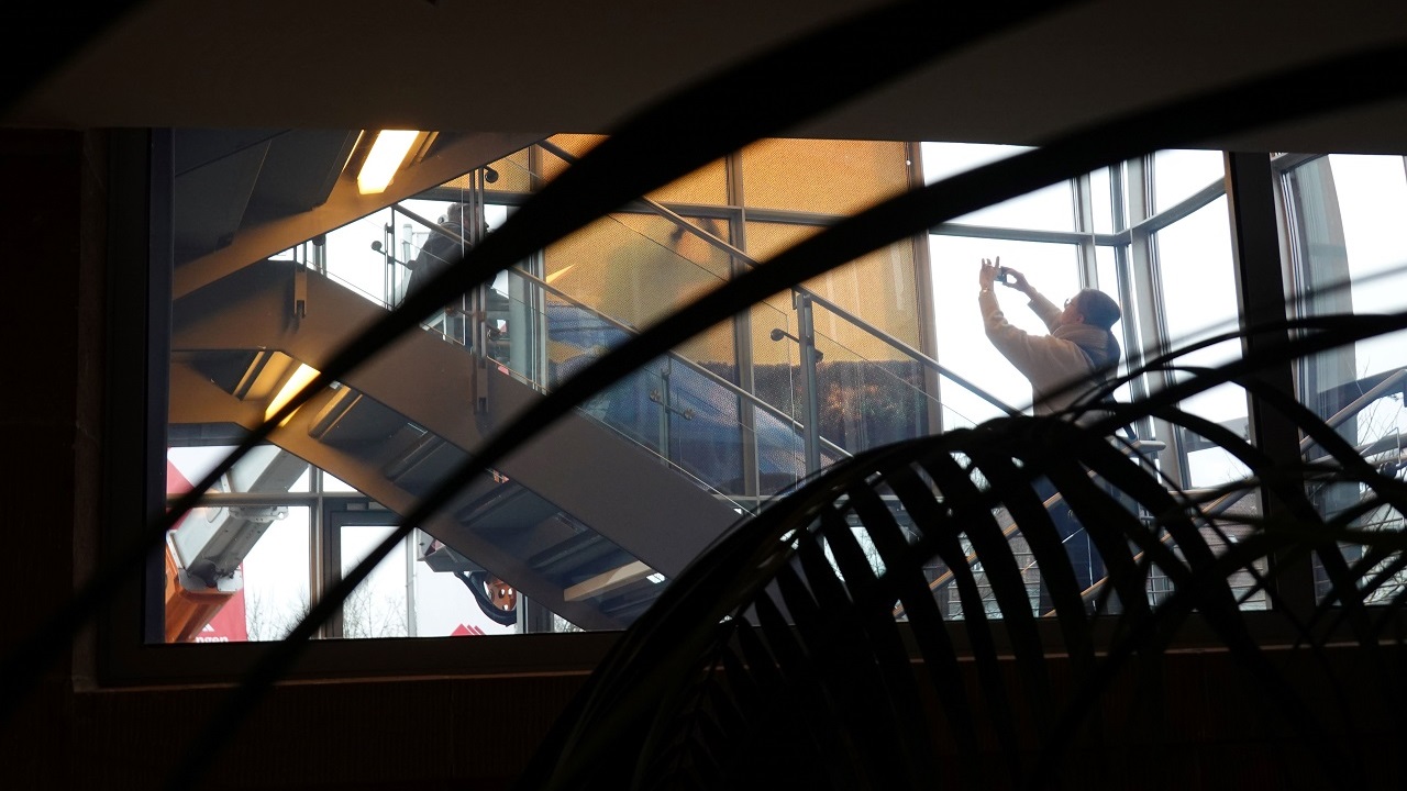 Simone Demandt. GOLDEN Blick auf das Treppenhaus der Stadthalle Göppingen. Im Hintergrund wird mit einem Mobiltelefon die Installationsarbeit des Werkes "GOLDEN" fototgrafiert.