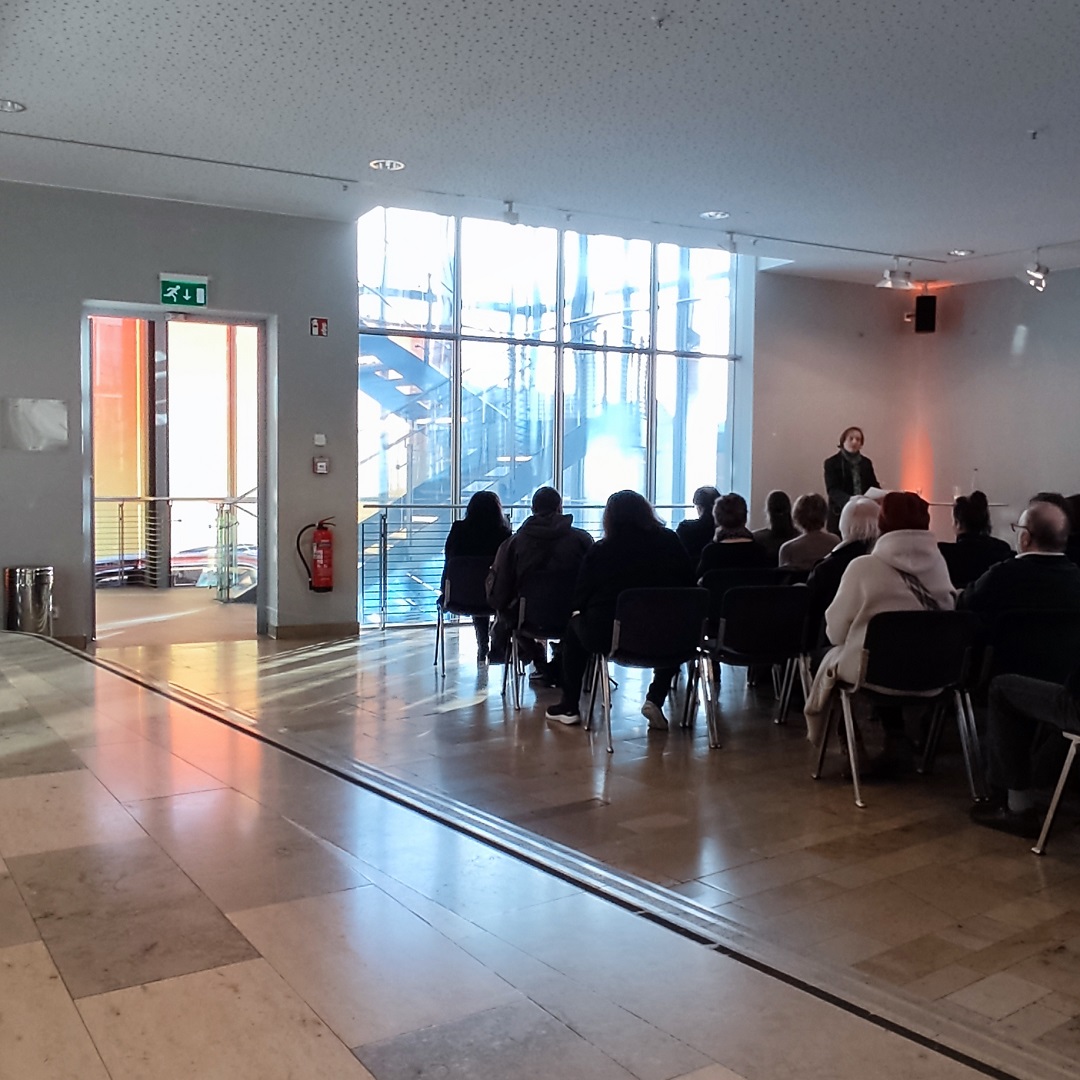 Vorstellung der Installation „Golden“ von Simone Demandt Dr. Kai Bleifuß spricht vor Publikum im Foyer der Stadthalle Göppingen über die Installation Golden von Simone Demandt; zahlreiche Besucherinnen und Besucher hören aufmerksam zu.