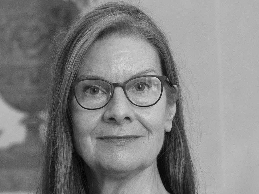 Simone Demandt Schwarz-weißes Porträt von Frau Simone Demandt mit langen Haaren und Brille, die ruhig in die Kamera blickt.