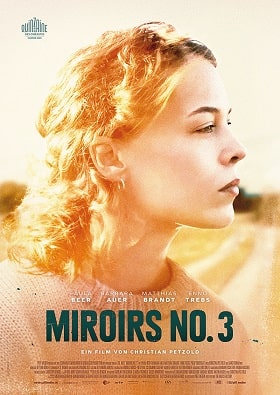 Filmplakat zu Miroirs No. 3: Eine blonde Person im Profil blickt konzentriert nach rechts, umgeben von warmem Sonnenlicht und einer unscharfen Landschaft im Hintergrund. Unten steht groß der Filmtitel „MIROIRS NO. 3“, darüber die Namen des Ensembles, am oberen Rand ein Festival-Logo.