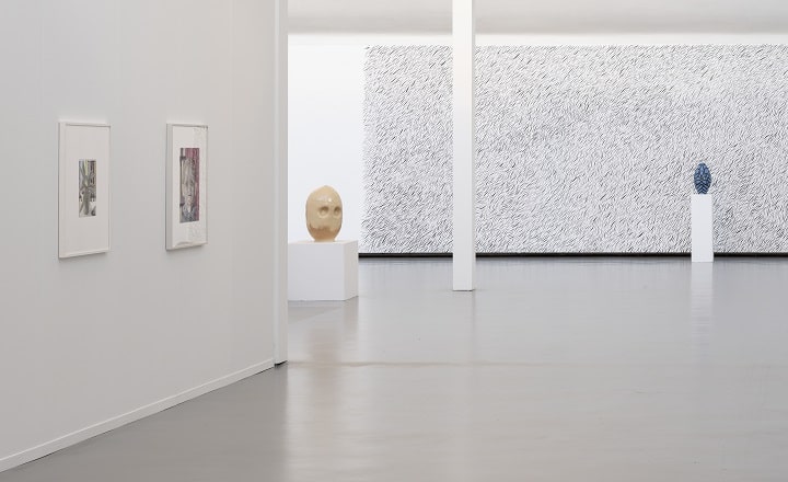 Ausstellungsansicht in der Kunsthalle Göppingen mit Zeichnungen an der Wand, einer keramischen Skulptur auf einem Sockel und einer großformatigen, strukturierten Arbeit im Hintergrund; heller, reduzierter Raum mit viel Abstand zwischen den Werken.