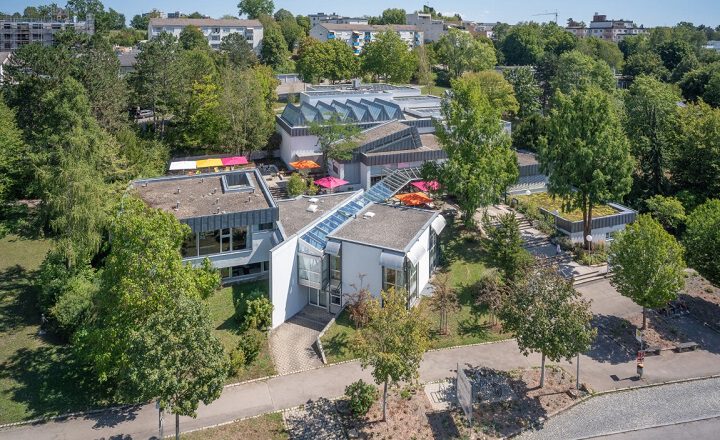 Luftaufnahme der Kunsthalle Tübingen mit ihrem modernen, flachgebauten Gebäudekomplex, umgeben von Bäumen und Grünflächen, eingebettet in ein Wohngebiet.