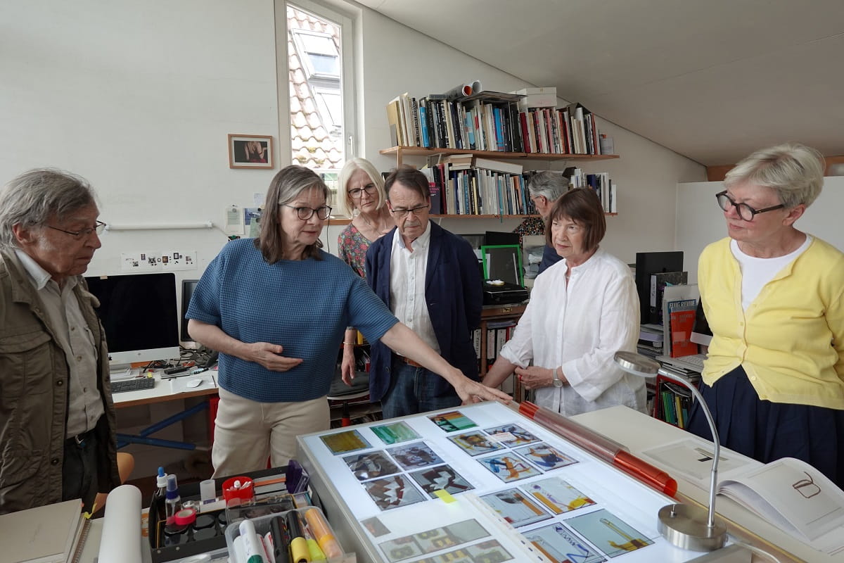 Simone Demandt erläutert Mitgliedern des Kunstvereins Göppingen in ihrem Atelier fotografische Arbeiten und Entwürfe auf einem Leuchttisch.